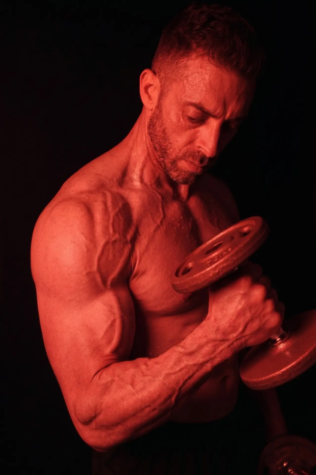 Adam curling a dumbbell under red light